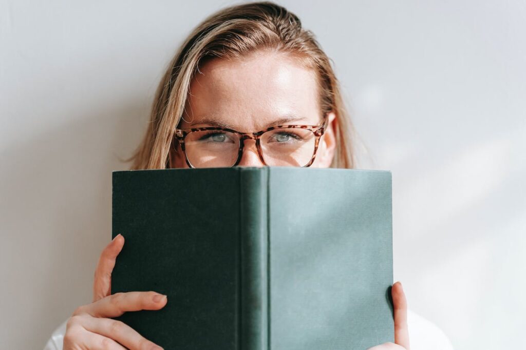 A girl  is reading a hardcover book